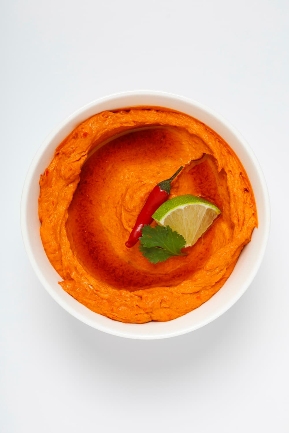 Bowl of Smart Gourmet Chili Hummus with red chili and lime